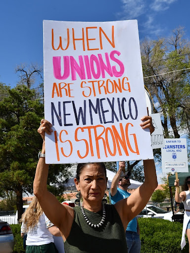 Deb Haaland holding a sign during a public protest.